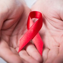 two hands holding red AIDS awareness ribbon