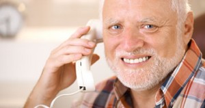 older man with white hair and beard talking on landline