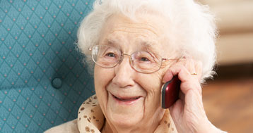 senior woman smiling while talking on red cell phone