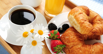 beautiful breakfast of coffee, croissants, berries and orange juice