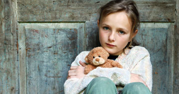 young homeless girl holding teddy bear
