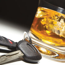 glass of hard alcohol on the rocks with set of car keys
