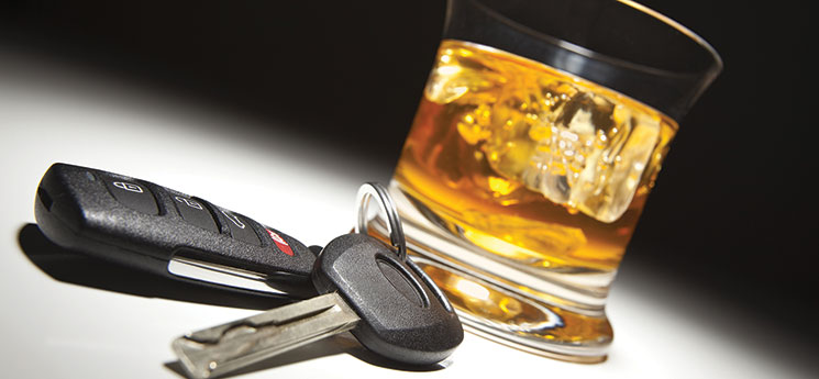 glass of hard alcohol on the rocks with set of car keys