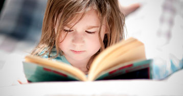 young girl absorbed in her book