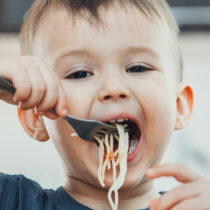 young boy eating spaghetti