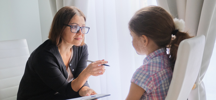 young girl talking with child psychiatrist